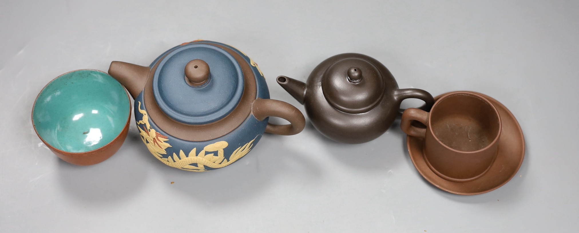 A 19th century Chinese Yixing cup, two later teapots and a cup and saucer